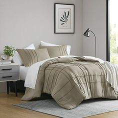 a bed in a room with a white and brown comforter on top of it