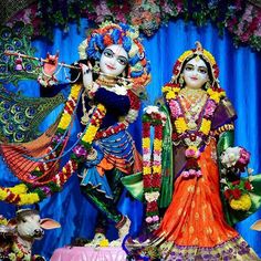 an idol is displayed in front of a blue backdrop with flowers and other decorations on it