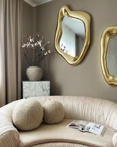 a living room filled with furniture and two mirrors on the wall above it's headboard