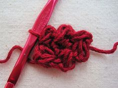 a red crochet hook with yarn on it