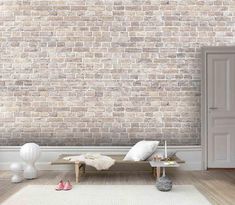 a living room with a brick wall and white furniture in front of the door,