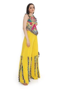 Yellow and multi color sleeveless back tie-up choli with all over bohemian tribe vibe embroidery and tassel embellishments. Paired with a mukaish dot embroidered sharara with tassel detailing. - Aza Fashions Fitted Multicolor Embellished Sharara, Fitted Embellished Multicolor Sharara, Multicolor Embellished Saree Set, Embellished Multicolor Saree Set, Bohemian Multicolor Sets With Gota Work, Multicolor Embellished Festival Set, Embellished Multicolor Festival Set, Multicolor Bohemian Georgette Sharara, Multicolor Motifs Palazzo Set For Diwali