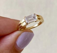 East To West Emerald Cut Moissanite Engagement Ring, Solitaire Half Bezel Double Row Band Ring, Daily Wear Ring, Gift For Her, 14K Gold Ring Item Description: Stone - Moissanite & Simulated Diamond Shape-  Emerald Cut  1. White Gold: 10K/14K/18K 2. Yellow Gold: 10K/14K/18K 3. Rose Gold: 10K/14K/18K 4. Silver: Sterling Silver 925 Size Customization: What Size you want... * You can also Customize ring size in US 4 to US 12! It sometimes affects to price. * Main Stone & Shape Customization: Main Stone: Cubic Zirconia, Moissanite, Natural Diamond, CVD Diamond Shape Choice: Round Cut, Heart, Princess Cut, Pear Cut, Cushion Cut, Marquise, Oval Shape, Asscher, Emerald, Radiant, Old European Cut, Old Mine Cut * Check out Special Notes: At checkout, leave us a note in the message box for the Ring s Diamond Index Finger Ring, Double Band East West Ring, Horizontal Ring Engagement, Sideways Rectangle Engagement Ring, Signet Engagement Rings Women, Horizontal Wedding Ring, Sideways Emerald Engagement Ring, Thick Band Engagement Ring Gold, East West Emerald Engagement Ring