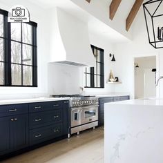 a kitchen with an oven, stove and counter tops in white and navy blue cabinets