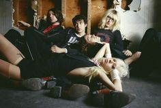 a group of young women sitting next to each other on the floor with skateboards