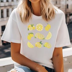 Add a Splash of Citrus Charm with Our Cute Lemon T-Shirt! Squeeze some sunshine into your wardrobe with our delightful lemon-themed t-shirt. Perfect for those who love a pop of cheerful color and a touch of whimsy, this tee is as refreshing as a cool glass of lemonade on a summer day. Why You'll Love It: 🍋 Zesty Design: Featuring a vibrant lemon print that radiates positivity and zest for life, this t-shirt adds a playful twist to your everyday style. 🌿 Soft & Comfortable: Made from 100% cotton, it's not just cute but also ultra-soft and breathable, ensuring all-day comfort wherever your adventures take you. 🎨 Versatile & Fun: Pair it with jeans, shorts, or a cute skirt - this tee effortlessly brightens up any outfit, making it a go-to choice for casual outings and laid-back days. Key F White T-shirt With Lemon Print For Summer, Summer Short Sleeve Top With Lemon Print, Yellow Crew Neck Top With Lemon Print, White Crew Neck T-shirt With Lemon Print, White Lemon Print T-shirt For Summer, White Summer Top With Lemon Print, White Summer Tops With Lemon Print, White Lemon Print Summer Top, White Short Sleeve T-shirt With Lemon Print