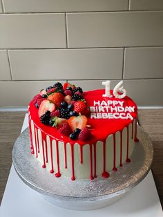 a red and white cake with fruit on top