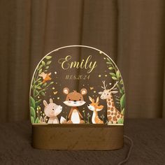 a personalized night light with animals and plants on the front, featuring an image of a baby's name