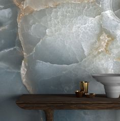 a table with two cups on it next to a wall that has a marble pattern