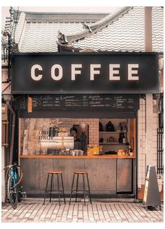 a coffee shop with two stools in front of it and a bicycle parked outside