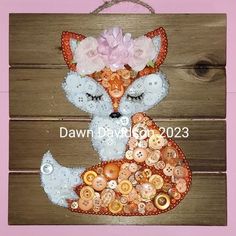 an image of a fox made out of buttons on a wooden board with pink flowers