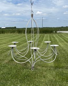 a metal chandelier in the middle of a field