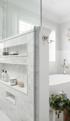 a bath room with a tub a sink and a shelf on the wall next to it