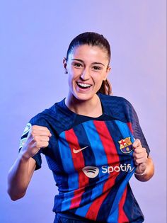 a woman in a blue and red soccer uniform