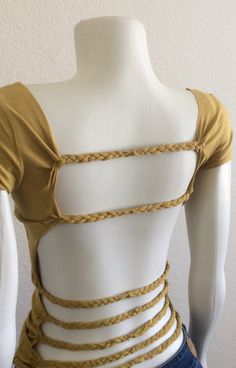 a mannequin wearing a yellow top with braids on it's back