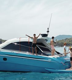 people standing on the back of a boat in the water