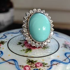 Size: 5 US 49 EU (FREE RESIZING) Metal Type: 18k white gold Weight: 16.6 grams Diamonds weight: 1.20 ct. Color:H Clarity: VSI Natural turquoise: 15mm x 19mm Condition: excellent  Introducing our Vintage 1960s sky blue turquoise and 1.20 ct. Diamond 18k Solid White Gold Statement Ring- a perfect blend of vintage charm and modern elegance. This ring is meticulously crafted from 18k solid white gold, ensuring a timeless appeal and lasting durability. The ring features a beautiful soft blue turquoise at their center, adding a touch of natural beauty and sophistication to the piece. Surrounding the stone is a halo of sparkling altogether 1.20 ct. diamonds, adding a touch of luxury and brilliance to the ring. These diamonds are carefully set to catch the light from every angle, making the ring s Formal Turquoise Diamond Ring With Gemstone, Formal Turquoise Diamond Ring, Formal Fine Jewelry Turquoise Diamond Ring, Elegant Turquoise Cabochon Diamond Ring, Formal Oval Turquoise Ring With Diamond, Oval Diamond Turquoise Ring For Formal Occasions, Elegant Turquoise Gemstone Ring For Formal Occasions, Classic Turquoise Ring For Formal Occasions, Formal Turquoise Cabochon Ring Fine Jewelry