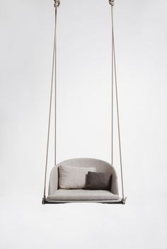 a swing chair with two pillows on it