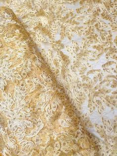 the fabric is gold and white with an intricate design on it's side,