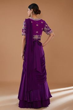 Purple can can attached draped lehenga saree in layered silhouette embellished by sequins and border frill detail. Comes with padded thread floral embroidered blouse and sequin embellished belt. - Aza Fashions Purple Pre-draped Saree For Wedding, Silk Draped Sets For Weddings, Anarkali Draped Dresses With Zari Work, Art Silk Cutdana Dress For Reception, Silk Dress With Sheer Dupatta And Traditional Drape, Traditional Drape Dress For Eid Reception, Festive Draped Dress With Resham Embroidery, Art Silk Gown With Sheer Dupatta, Silk Draped Sharara For Wedding