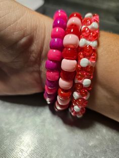 This Valentine's Day inspired beaded bracelet set is fun for everyone! Great for parties, concerts and more! Includes the colors: red, pink, majenta and white. Trendy Red Beaded Bracelets With Colorful Beads, Pink Party Stretch Bracelet With Colorful Beads, Party Pink Stretch Bracelet With Colorful Beads, Fun Pink Beaded Bracelets For Party, Pink Stretch Bracelet With Colorful Beads For Party, Fun Red Beaded Bracelet, Trendy Pink Stretch Bracelet For Party, Adjustable Pink Stretch Bracelet For Valentine's Day, Red Friendship Bracelets With Round Beads