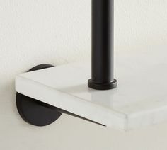 a white shelf with a black pipe on it