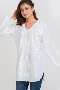 Our Divya White Tunic is one of our best selling tunics. This beautiful cotton tunic is hand embroidered by women artisans in Northern India in the shadow-work style known as “Chikankari“. Chikankari is a delicate and artfully done hand embroidery that women in this region have been doing for generations. With a comfortable, elegant cut, this fair trade tunic is a contemporary twist on the classic Indian kurti. White Embroidered Kurti, Embroidered Cotton Top, White Tunic Tops, Embroidered Kurti, Fair Trade Clothing, Three Quarter Sleeve Tops, Embroidered Tunic Top, White Tunic, Caftan Dress