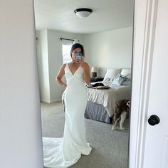 a woman in a white dress taking a selfie with her cell phone while standing in front of a mirror