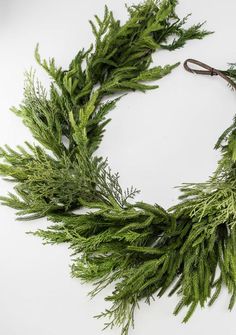 a close up of a wreath on a white surface with scissors in the foreground