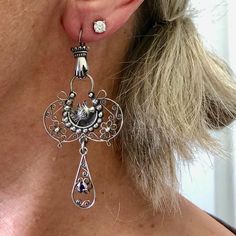 A delicate and whimsical design for these fillagree silver earrings. Classic motifs with Mexican hand and bird milagros. Layers of fillagree swirls, flowers, and hand engraved detail end with an amethyst drop.  A lightweight lacy statement chandelier earring! Metal - sterling silver marked 925 with makers mark MG - 44, they were made in Mexico City Gem - Amethyst Earrings are 70mm or 2 3/4 inch long from top of hook to bottom of drop, and 32mm, at widest point *The pictures are part of the descr Ornate Hallmarked Dangle Chandelier Earrings, Ornate Hallmarked Chandelier Dangle Earrings, Ornate Sterling Silver Chandelier Earrings, Bohemian Filigree Earrings For Anniversary, Hallmarked Sterling Silver Chandelier Earrings, Sterling Silver Hallmarked Chandelier Earrings, Ornate Sterling Silver Pierced Chandelier Earrings, Ornate Sterling Silver Nickel-free Chandelier Earrings, Antique Sterling Silver Dangle Earrings