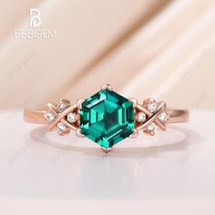 an emerald colored ring with diamonds on it