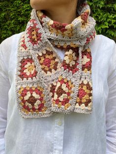 a woman is wearing a crocheted scarf