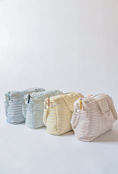 three bags sitting side by side on a white surface