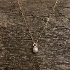 Dainty and minimal - gold filled necklace with a Swarovski pearl centre. Beautiful and elegant . Chain is adjustable Material : 14K gold filled Size : 5mm pearl Length : 16+2 inches Comes in a gift boxGold filled should NOT be confused with gold plating. It is an actual layer of solid gold, pressure bonded to another metal. Gold filled not only uses the double amount of gold , It’s also more valuable and tarnish resistant and does not flake or rub off. It's great for people that have skin sensit Minimalist Gold Charm Necklace With Pearl, Gold Minimalist Charm Necklace With Pearl Chain, Gold Minimalist Charm Necklaces With Pearl Chain, Dainty 14k Gold Filled Pearl Necklace For Everyday, Minimalist Gold Charm Necklace With Pearl Chain, Minimalist 14k Gold-filled Pearl Necklace For Everyday, Minimalist Everyday Pearl Necklace With 14k Gold Filled, Minimalist Gold Charm Necklace With Pearl Pendant, Dainty 14k Gold-filled Yellow Gold Pearl Necklace