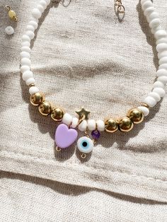 ⩆ ITZY ⩆ Boho white and gold summer style bracelet.  please note This listing is for the purple bracelet.  * It has lovely colourful and gold charms including Greek protection eye, colourful heart, gold dainty star and a gemstone bead. * It is perfect for layering with other bracelets for a boho beach style. * Gift for her, mum or friends, Christmas present.  * made of stainless steel ( hypoallergenic ) Rocaille seed beads, acrylic, purple Jade gemstone and glass.  ------------------------------ Dainty White Bracelets With Colorful Beads, Bohemian Charm Bracelet With White Round Beads, Gold Bracelets With Heart Beads For Beach, Bohemian White Charm Bracelet With Round Beads, Gold Friendship Bracelets With Heart Beads For Beach, Trendy White Jewelry With Heart Charm, Trendy White Charms Jewelry, Dainty White Charm Bracelet For Everyday, Trendy White Heart Charm Bracelet