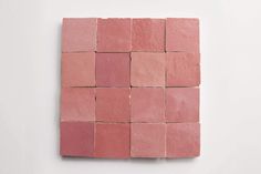 a pink square shaped tile on a white wall