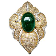 Introducing the Fancy Art Deco Pendant Brooch, a stunning and unique piece of jewelry that showcases exquisite craftsmanship and impeccable design. The centerpiece of this piece is a dazzling green oval cabochon emerald (weighing 19.46 cts) that radiates beauty and elegance. The emerald is surrounded by a pave-styled setting of white melee diamonds that enhance the brilliance and sparkle of the center stone, while the antique design in 18K white and yellow gold adds a touch of sophistication and class to the piece. Pendant Brooch, Fancy Art, Green Oval, Art Deco Pendant, Antique Design, Green Emerald, Oval Cabochon, Fashion Set, Unique Pieces