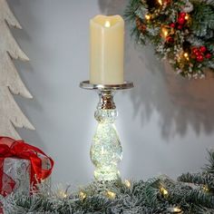 a lighted candle on top of a christmas tree