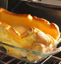 a casserole dish with bread and cheese in it on an oven rack, ready to be cooked