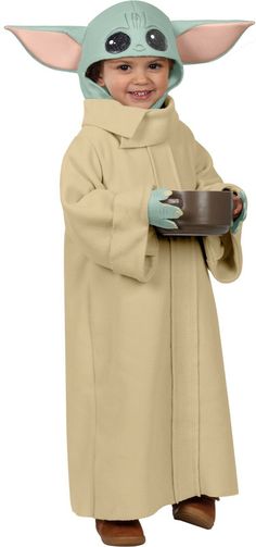 a young child dressed as yoda holding a plate with a chocolate cake in it