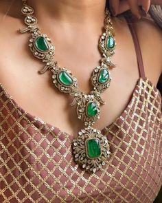 This exquisite Victorian doublets statement necklace set in emerald green captures the essence of opulence and vintage charm. The necklace, crafted with meticulous detail, features gleaming emerald green doublets set in an ornate Victorian-style framework. Each doublet, with its rich hue and intricate facets, reflects light beautifully, creating a mesmerizing play of colors.  The necklace cascades gracefully, adorned with smaller emerald accents and delicate filigree patterns that evoke the gran Luxury Hand Set Kundan Necklace, Formal Jewelry With Intricate Design And Emerald, Formal Emerald Jewelry With Intricate Design, Formal Intricate Emerald Jewelry, Opulent Jeweled Formal Jewelry, Opulent Jeweled Jewelry For Formal Occasions, Opulent Party Jewelry With Intricate Design, Ornate Green Jewelry With Jewels, Elegant Green Emerald Necklace With Jewels