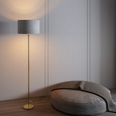 a floor lamp next to a round pillow on the floor