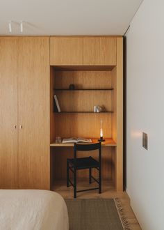 a bedroom with a bed, desk and book shelf in the closet next to it