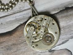 This is a vintage watch movement, just the gears. It doesn't work its just for the beauty of the inside of old watches. A conversation piece. Authentic antique/vintage pocket watch movement. Great piece for your steampunk look. I T E M ∙ S P E C I F I C A T I O N S - NECKLACE: 28" stainless steel bead ball chain - PENDANT: Watch gears are 1 1/8" round, backing is glued and makes the pendant 1 1/2" long C A R E ∙ T I P S We don’t want your special moment to fade. To maintain the quality of your j Steampunk Silver Pocket Watch With Locket, Silver Steampunk Pocket Watch With Locket, Steampunk Silver Pendant Necklace, Steampunk Silver Necklace With Round Pendant, Antique Silver Nickel-free Pocket Watch, Silver Steampunk Pendant Necklace, Antique Nickel-free Silver Pocket Watch, Silver Steampunk Necklace With Round Pendant, Watch Gears