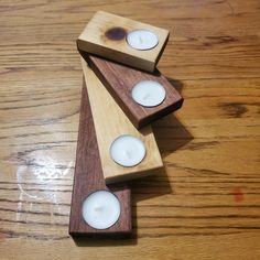 three wooden candles sitting on top of each other in front of a wood flooring