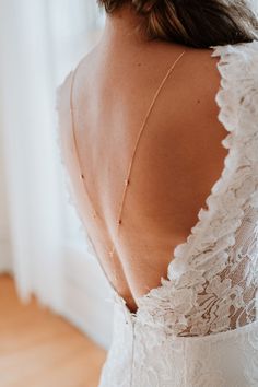 the back of a woman's wedding dress, with her hand on her hip