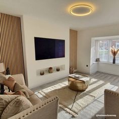 a living room filled with furniture and a flat screen tv mounted on the wall next to a window