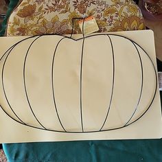 a paper pumpkin sitting on top of a table next to some other pieces of cloth