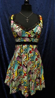 "An adorable cocktail dress in a colorful vintage foodie print. Ice cream, hot dogs, popcorn, cheeseburgers are all depicted on this 100% cotton fabric. Black overlock stitching on reversed seams gives the dress a punk deconstructed look. Wide black lace trimming at neckline and midsection adds a touch of subtle elegance. Adjustable shoulder straps can be worn tied down in back, or tied at back of neck - halter style. Zips in back. This dress has a very cute, flattering fit for all body shapes! Retro Sleeveless Dress With Graphic Print, Retro Cotton Dress For Party, Retro Cotton Party Dress, Retro Cotton Dress With Graphic Print, Retro Fitted Dress With Graphic Print, Fitted Retro Dress With Graphic Print, Retro Printed Cotton Dresses, Retro Cotton Printed Dress, Retro Vintage Print Patterned Dress