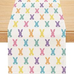 a white table runner with colorful rabbits on it